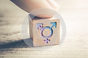 Transgender, LGBT or Intersex Icon On A Wodden Block On A Table Arranged By A Finger