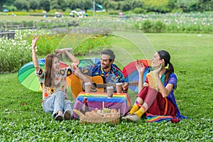 Transgender person with LGBTQ friends enjoying together at picnic in park