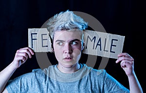 Transgender teenager breaking the word FEMALE into MALE. Gender identity and human rights concept