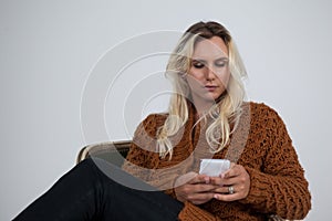 Transgender using mobile phone while sitting on chair