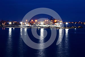 Transhipment terminal for discharging cement cargo by shore cranes. A view of berths with cargo ships and the water area of the po