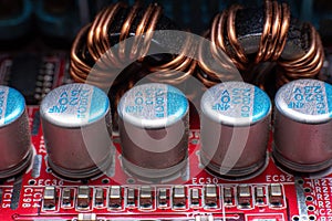 Transistors and coils on a red motherboard