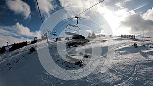 Transition from dark hand, first-person view of a ski lift. Chairlift POV