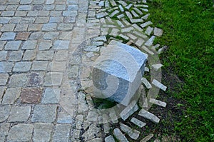 Transition of paved surfaces between paving and lawn. the lawn grows between individual randomly placed stones of granite chipped