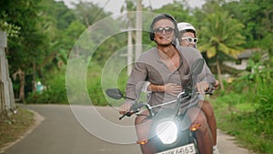 Transition shot from road to couple riding a motorbike. Happy man, woman travel by motorcycle on tropical road