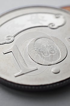 Translation: 10 New Taiwan dollars. Taiwanese money lie on gray surface. Vertical illustration about economy or finance. Coins of