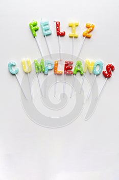 Translation: Happy birthday. Words in Spanish formed with candle letters. photo
