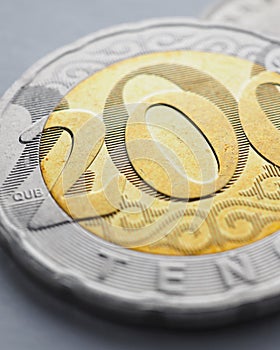 Translation: tenge. Kazakh money lies on light surface. Coin 200 tenge closeup. Economy and National Bank of Kazakhstan. National
