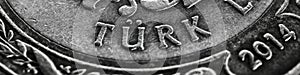 Translation: Turkish lira. Fragment of 1 lira coin close-up. National currency of Turkey. Black and white banner or header for