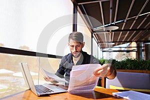 Translator sorting papers and closing laptop lid.