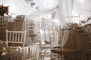 Translucent chairs in a wedding tent