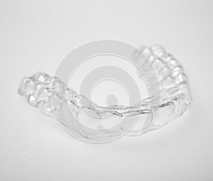 Translucent essix retainer on a gray background