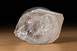 Translucent smoky quartz mineral from Brazil over a wooden table