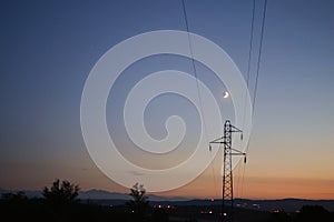 A transmission tower on the background of the Moon