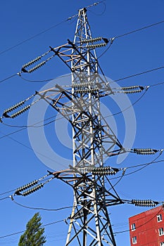 A transmission tower on the background of a red residential building