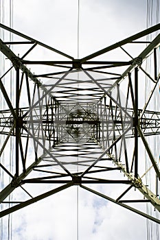 Transmission tower bottom view. Power tower on cloudy sky. Electricity pylon structure for power line. High voltage post