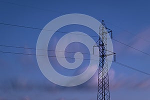 Transmission tower or electricity pylon and overhead power line in long exposure