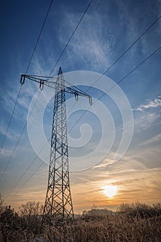Transmission tower - high voltage power lines in colorful sunset