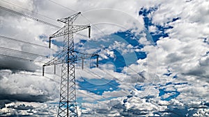 Transmission tower top part silhouette on blue sky background and white clouds