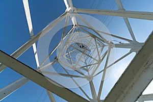 Transmission tower, view from below. Overhead pylon power line tower, distribution and transmit electrical energy across large