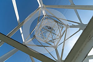 Transmission tower, view from below. Overhead pylon power line tower, distribution and transmit electrical energy across large