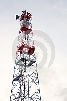 Transmitters and aerials on telecommunication tower, sunset in snowy country