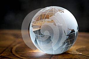 Transparency global, world or international concept with decoration glass globe on vintage book with dark background