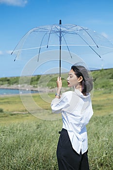 Transparency umbrella and young asian woman under blue sky