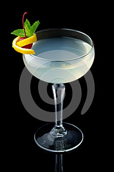 Transparent alcohol cocktail with mint and cherry isolated on black