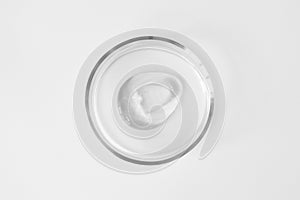 Transparent aloe gel smudge in glass petri dish on white background. Concept laboratory tests and research, making cosmetic