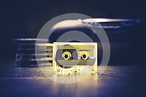 Transparent audio cassette tape lit by yellow and blue lamps