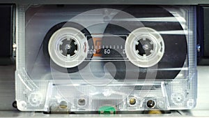 Transparent Audio Cassette Tape Rolling in Deck Player, Close Up