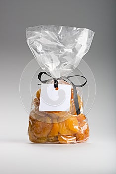 Transparent bag of candied apricots with ribbon and blank label