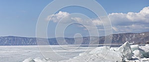 Transparent blue ice hummocks on lake Baikal shore. Siberia winter landscape view. Snow-covered ice of the lake. Big