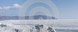 Transparent blue ice hummocks on lake Baikal shore. Siberia winter landscape view. Snow-covered ice of the lake. Big