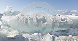 Transparent blue ice hummocks on lake Baikal shore. Siberia winter landscape view. Snow-covered ice of the lake. Big