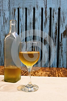 Transparent bottle and glass of white on table. Wooden background in rustic style