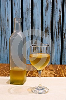 Transparent bottle and glass of white on table. Wooden background in rustic style