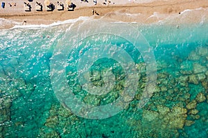 Transparent bottom and clear sea with turquoise water on the beach of island in Greece, top view from a drone