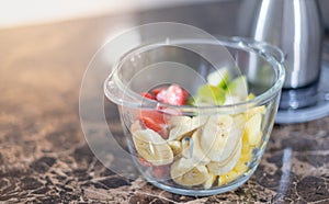 The transparent bowl of mix fruit and the knife inside preparing for made smoothies mix fruit, good for health and diets