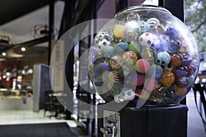 Transparent coin vending machine with colored plastic balls inside