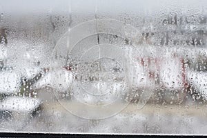 Transparent condensate in the foggy background, water dripping on clear glass. Drops of condensation close-up macro. Steam on the