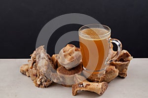 Transparent Cup of bone broth is placed on boiled beef bones, which contain the necessary amino acids for the body. Selective