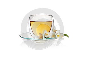 Transparent cup of green tea with jasmine flowers isolated on white background