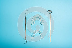 Transparent dental aligner next to dentist mirror, copy space