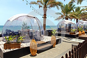 Transparent domed gazebo in style of an igloo for romantic dates of lovers. Open air restaurant