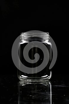 a transparent empty jar with black background