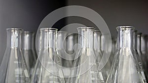 Transparent Erlenmeyer flasks or conical flasks on shelf in science laboratory, use for measuring solvent or solution.