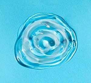 Transparent gel drop. Liquid cream gel cosmetic smudge texture on blue background