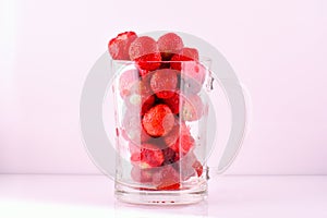 Transparent glass bowl with strawberries on white background